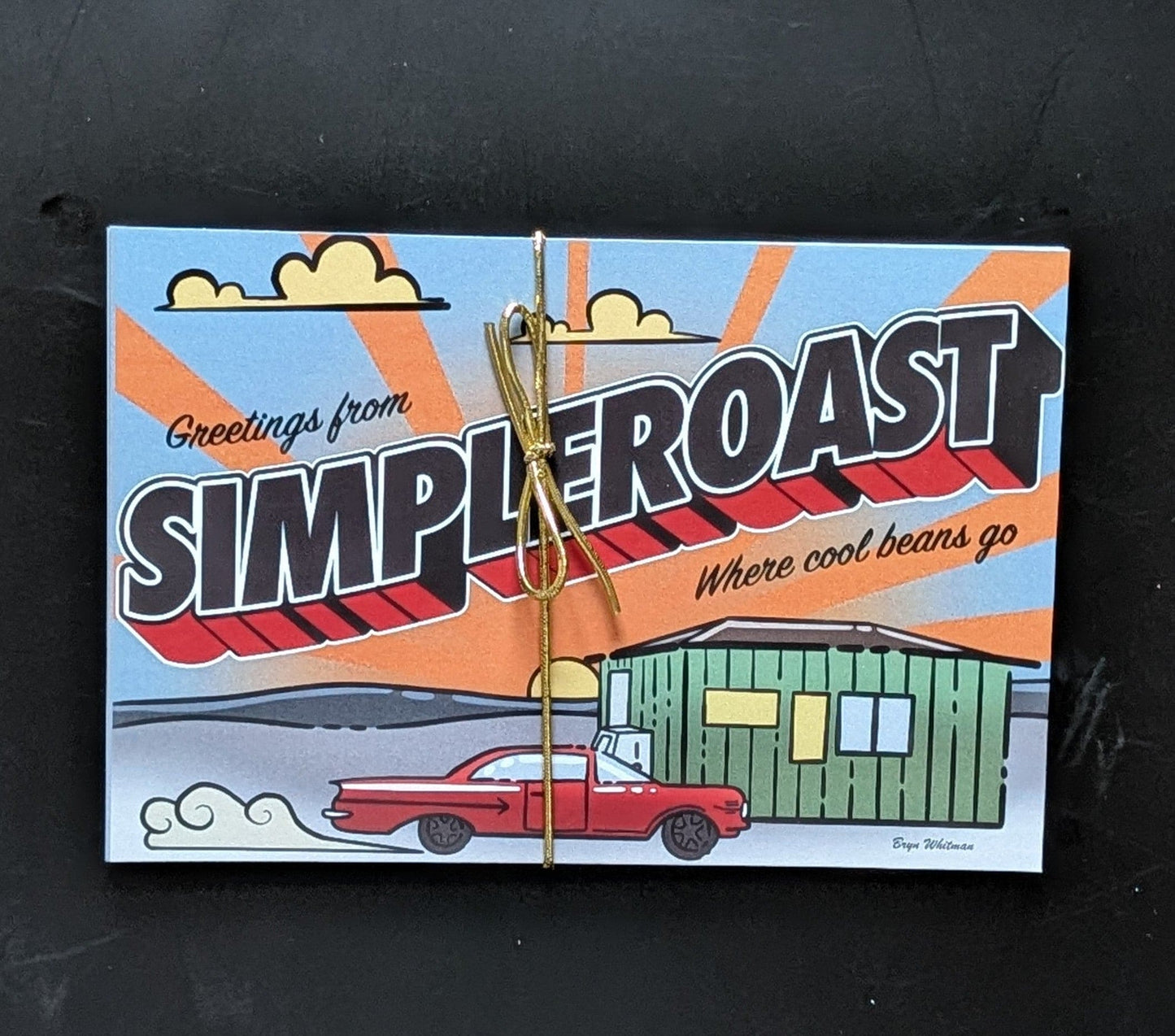 Simple Roast 5-pack postcards tied with gold ribbon, featuring retro Greetings from Simple Roast design with red car and green building
